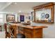 Basement bar featuring hard wood cabinets, a black counter top, and a shelf with glassware at 11830 Snowshoe Dr, Parker, CO 80138