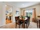 Cozy dining room with view of the kitchen, a wooden table, leather chairs, and window with curtains at 11830 Snowshoe Dr, Parker, CO 80138