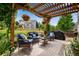 Relaxing covered patio featuring comfortable seating, a grill, and views of the backyard at 11830 Snowshoe Dr, Parker, CO 80138