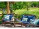 Cozy patio with wicker furniture, decorative pillows, and a coffee table in a serene outdoor setting at 11830 Snowshoe Dr, Parker, CO 80138