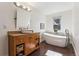 Bright bathroom featuring a stand-alone tub, wood cabinets, and a large mirror at 1965 Jasmine St, Denver, CO 80220