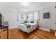 Bright bedroom with wood floors, and two windows with white curtains at 1965 Jasmine St, Denver, CO 80220