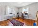 Bright bedroom with wood floors, and two windows with white curtains at 1965 Jasmine St, Denver, CO 80220