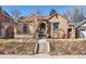 Charming brick home with a tile roof, inviting entrance, and well-maintained landscaping at 1965 Jasmine St, Denver, CO 80220
