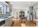 Open kitchen with stainless steel appliances, tile backsplash, and a cozy dining area with natural lighting at 1965 Jasmine St, Denver, CO 80220