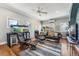 Spacious living room with hardwood floors, a ceiling fan, and abundant natural light from large windows at 1965 Jasmine St, Denver, CO 80220