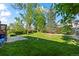 A sprawling backyard features lush grass and mature trees, ideal for outdoor enjoyment at 9430 Osceola St, Westminster, CO 80031