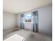 Simple bedroom with a large window, neutral carpeting, and light blue walls at 9430 Osceola St, Westminster, CO 80031