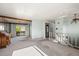 Open-concept living room featuring sliding door access to a deck, wood beam, and neutral carpeting at 9430 Osceola St, Westminster, CO 80031
