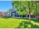 Spacious backyard with lush green lawn, patio, and mature trees at 4643 S Vivian Ct, Morrison, CO 80465