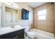 Bright bathroom features a tub with shower, tiled walls, and vanity with storage at 4643 S Vivian Ct, Morrison, CO 80465