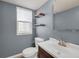 Half bath features a modern vanity, toilet, mirror, and floating shelves at 4643 S Vivian Ct, Morrison, CO 80465