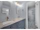Bathroom features a double vanity, stylish lighting, and a glass shower with stone floor at 4643 S Vivian Ct, Morrison, CO 80465