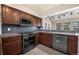 Well-equipped kitchen featuring dark cabinetry, stainless appliances, and granite counters at 4643 S Vivian Ct, Morrison, CO 80465