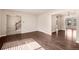 Open-concept living room with hardwood floors and neutral walls leading to stairway and sunroom at 4643 S Vivian Ct, Morrison, CO 80465