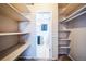 Walk-in closet features a shelving system and a view into the ensuite bathroom with blue vanity at 4643 S Vivian Ct, Morrison, CO 80465
