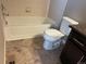 Traditional bathroom featuring a standard white bathtub and toilet with tile flooring at 4280 E Warren Ave # 2, Denver, CO 80222