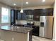 Modern kitchen with dark wood cabinets, stainless steel appliances, and granite countertops at 4280 E Warren Ave # 2, Denver, CO 80222