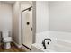 Bathroom featuring a tiled shower, soaking tub, modern fixtures, and a toilet at 17935 E 94Th Ave, Commerce City, CO 80022
