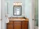 Bathroom showcasing a granite countertop, wooden cabinets, and a decorative mirror, all in a light-filled space at 5432 S Cathay Way, Centennial, CO 80015