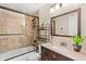 Well-lit bathroom featuring a shower-over-tub, vanity, and a decorative mirror at 5432 S Cathay Way, Centennial, CO 80015