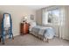 Cozy bedroom with a twin bed, wooden dresser, and natural light streaming through the sheer-curtained window at 5432 S Cathay Way, Centennial, CO 80015