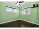 Light green bedroom with dark wood floors and two windows at 2930 N Fillmore St, Denver, CO 80205