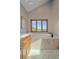 Bright bathroom featuring a soaking tub with marble surround and picturesque outdoor views from the large picture window at 17313 W 43Rd Dr, Golden, CO 80403