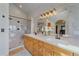Bright bathroom features a double vanity, large mirror, and glass-enclosed shower with elegant marble tile at 17313 W 43Rd Dr, Golden, CO 80403