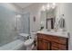 Stylish bathroom featuring a tiled walk-in shower with a bench, a modern vanity, and a decorative gold leaf at 17313 W 43Rd Dr, Golden, CO 80403
