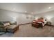 Spacious bedroom with a leather arm chair, dresser, and a bed with decorative throw pillows at 17313 W 43Rd Dr, Golden, CO 80403