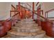 Grand foyer with curved staircase, dark wood trim and railing, and tile flooring on multiple levels at 17313 W 43Rd Dr, Golden, CO 80403