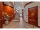 Hallway with wood trim, stairway, and tile floors leads to open living spaces with lots of natural light at 17313 W 43Rd Dr, Golden, CO 80403