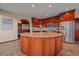 Spacious kitchen island with granite countertop, custom cabinets, and stainless steel refrigerator at 17313 W 43Rd Dr, Golden, CO 80403