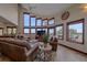 Bright living room features a wall of windows, leather furniture, and stunning views at 17313 W 43Rd Dr, Golden, CO 80403
