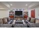 Living room featuring a modern fireplace, TV, shelving, and comfortable seating at 17313 W 43Rd Dr, Golden, CO 80403
