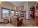 Living room with fireplace, tile floor, multiple windows, and comfortable seating arrangement at 17313 W 43Rd Dr, Golden, CO 80403