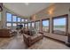 Bright living room with tile floor, multiple windows, ceiling fan, and comfortable seating arrangement at 17313 W 43Rd Dr, Golden, CO 80403