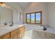 Bright and elegant bathroom featuring a soaking tub with scenic views and stylish fixtures at 17313 W 43Rd Dr, Golden, CO 80403