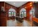 Cherry wood office features arched windows with views and dark wood desk and cabinets at 17313 W 43Rd Dr, Golden, CO 80403