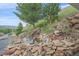 Picturesque backyard pond with rock features, a small waterfall, and lush landscaping, creating a serene outdoor oasis at 17313 W 43Rd Dr, Golden, CO 80403