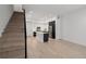 Sun-filled living room features sleek staircase and a modern kitchen with stainless steel appliances and eat-in island at 1815 N Williams St, Denver, CO 80218