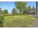 Expansive lawn and mature shade trees provide privacy to the rear yard with fire pit and covered patio at 7325 Taft Ct, Arvada, CO 80005