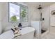 Sleek bathroom featuring marble-style walls, a soaking tub, and a modern rain shower head, complemented by a scenic window view at 7325 Taft Ct, Arvada, CO 80005