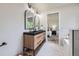 Well-lit bathroom featuring a modern double vanity and a glimpse of a luxurious soaking tub at 7325 Taft Ct, Arvada, CO 80005
