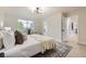 Bright bedroom boasts contemporary lighting, soft rug, neutral walls, and a large window showcasing the exterior view at 7325 Taft Ct, Arvada, CO 80005