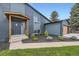 Entrance with black front door and wood porch cover and landscaped yard at 7325 Taft Ct, Arvada, CO 80005