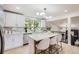 Modern kitchen featuring white cabinetry, an island with bar seating, and bright lighting at 7325 Taft Ct, Arvada, CO 80005