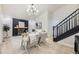 Sunlit living room with fireplace, modern lighting, and stairs at 7325 Taft Ct, Arvada, CO 80005
