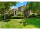 Well-maintained exterior with a manicured lawn, mature trees, and detailed landscaping around the home at 5155 W Quincy Ave # L101, Denver, CO 80236